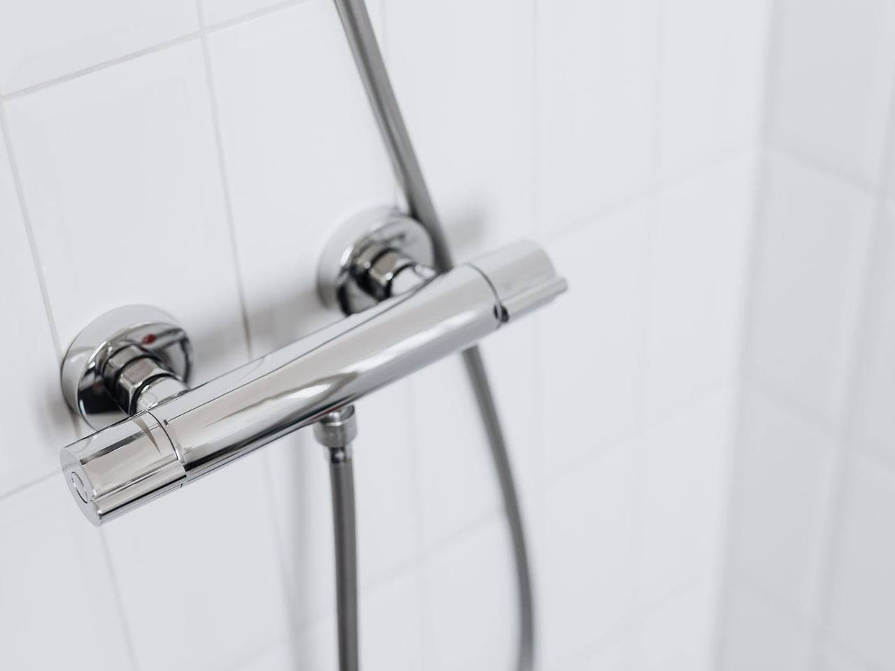 Termostatická sprchová baterie na bílém obkladu